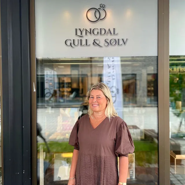 Kvinne i kjole utenfor Lyngdal Gull & Sølv As